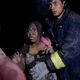 A rescue worker helps a woman covered with ash after Fuego volcano erupted violently in El Rodeo, Guatemala June 3, 2018. REUTERS/Fabricio Alonzo - RC1936B8FE70